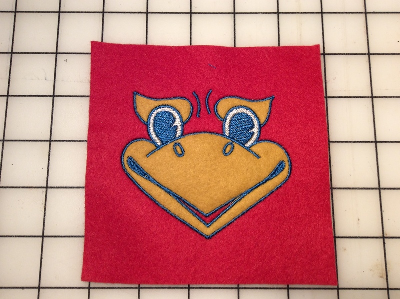 Embroidered Kansas Jayhawk mascot face on a piece of felt