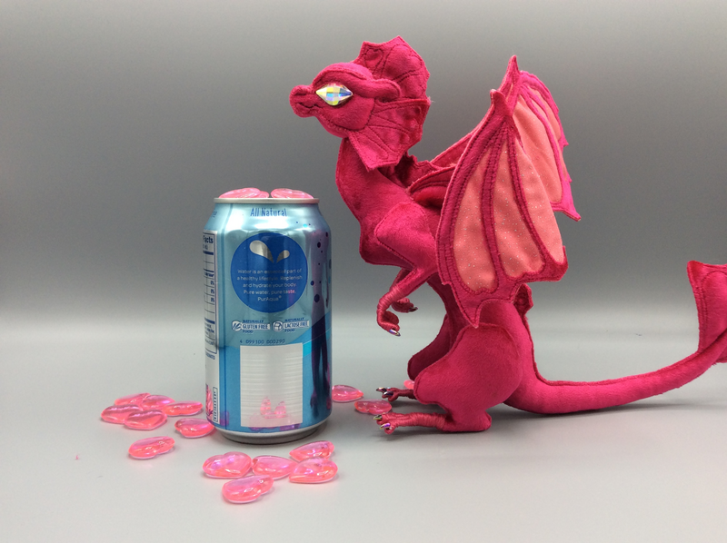 A bright fuchsia velvet dragon with hearts in its crests and wings, and Swarovski-like crystal eyes that are too large.