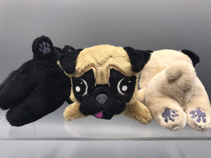 Three plush pugs at different angles.