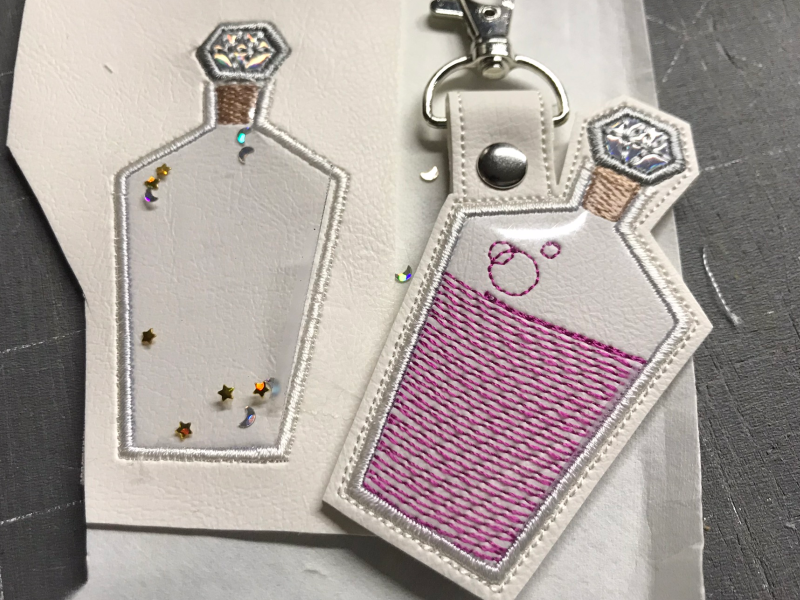 A failed glitter-inclusion fob, with a finished one that has stitching instead