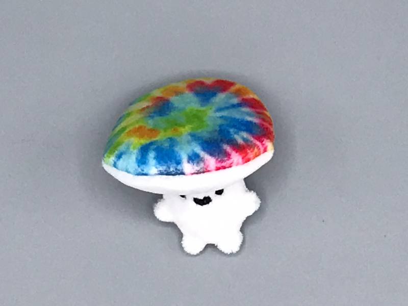 A plush toadstool person with a tie-dye cap