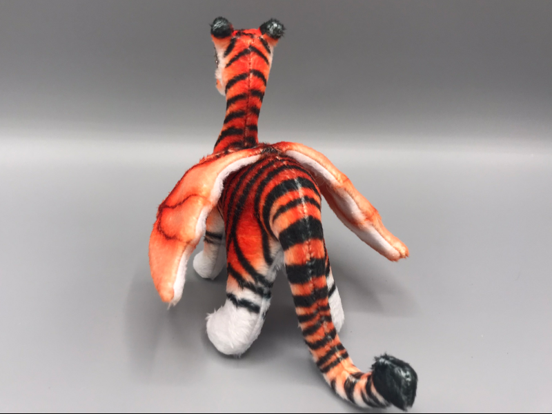 A tiger-striped plush dragon from the back