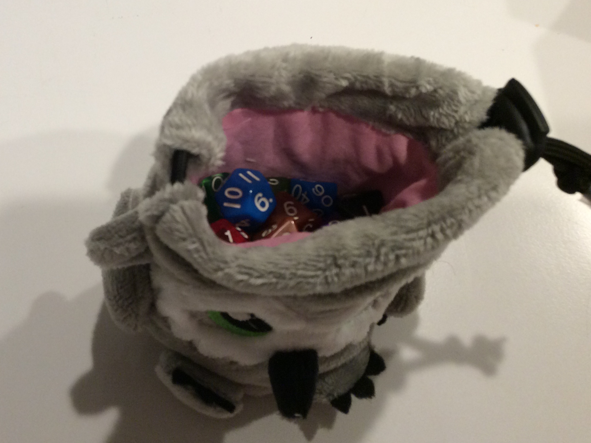 Looking into the drawstring opening of a tiny plush owlbear that is also a dice bag.
