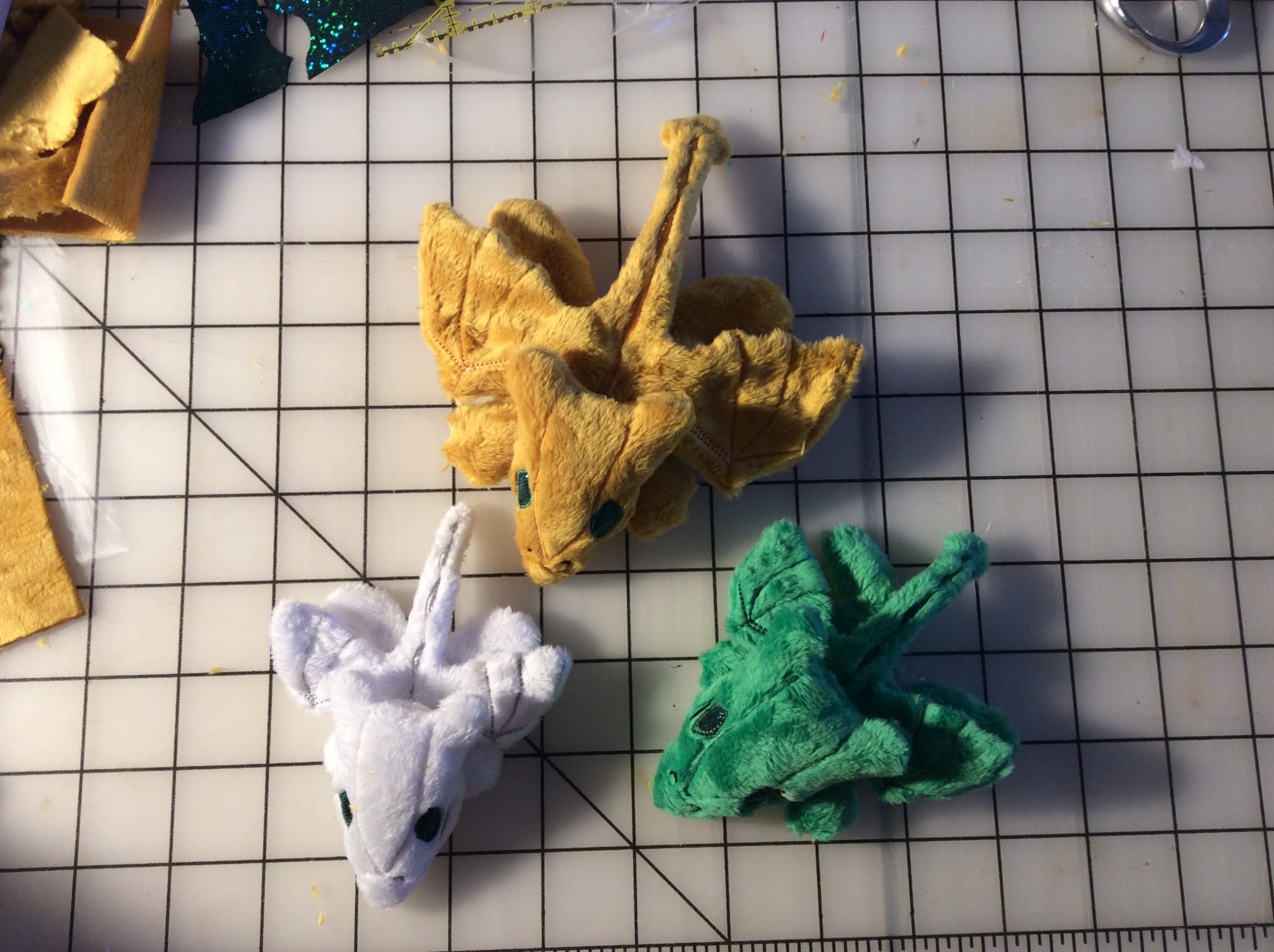 Three different sizes/proportions of tiny plush dragons.