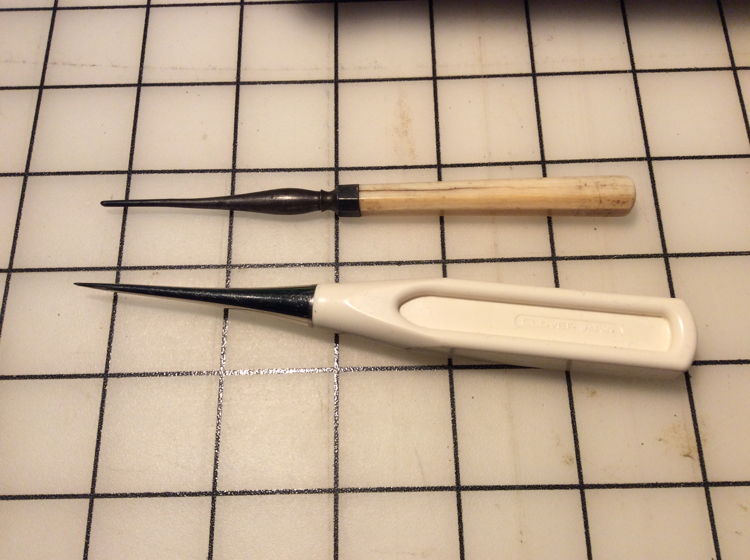 An antique tailor's awl compared to a new one.